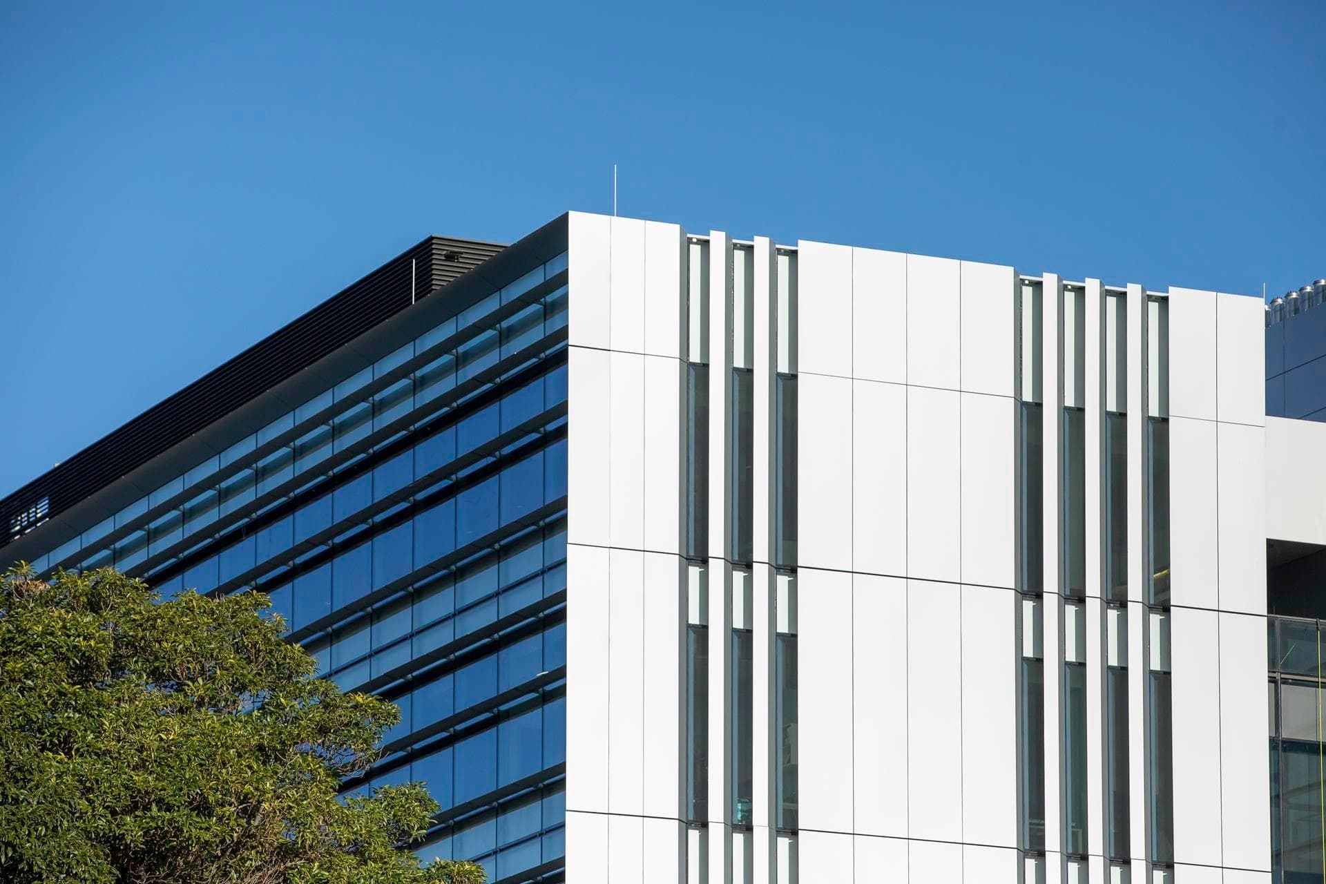 Wide view of the Charles Perkins Centre showing Alpolic NC façade panels in white alongside reflective glass curtain walls.