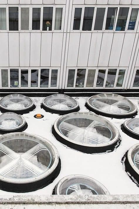 Close-up view of circular daylight ceiling elements using anodised aluminium light pipes at Blue Hospital