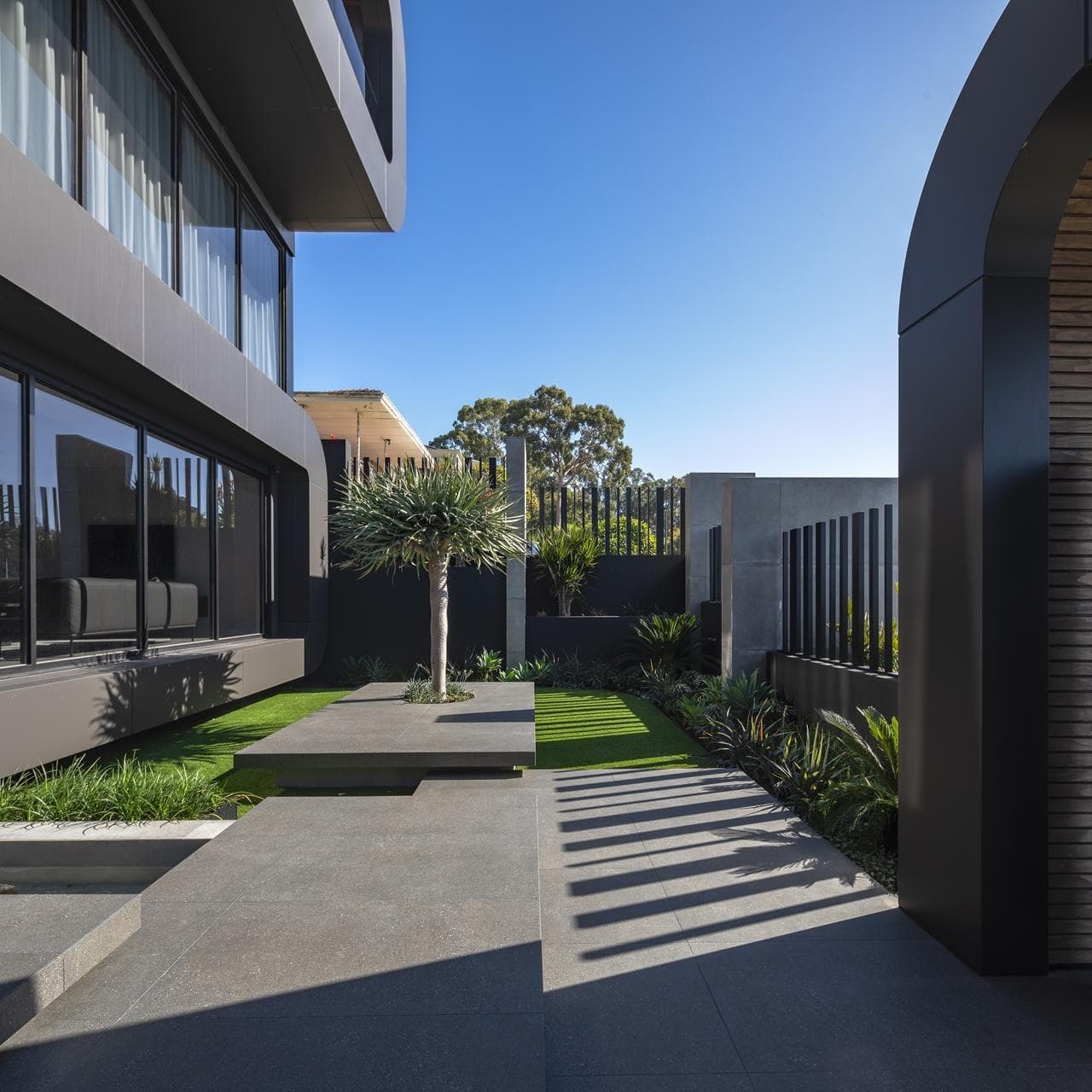 Side garden courtyard framed by ALPOLIC™/fr Matte Slate Black cladding and minimalist landscaping