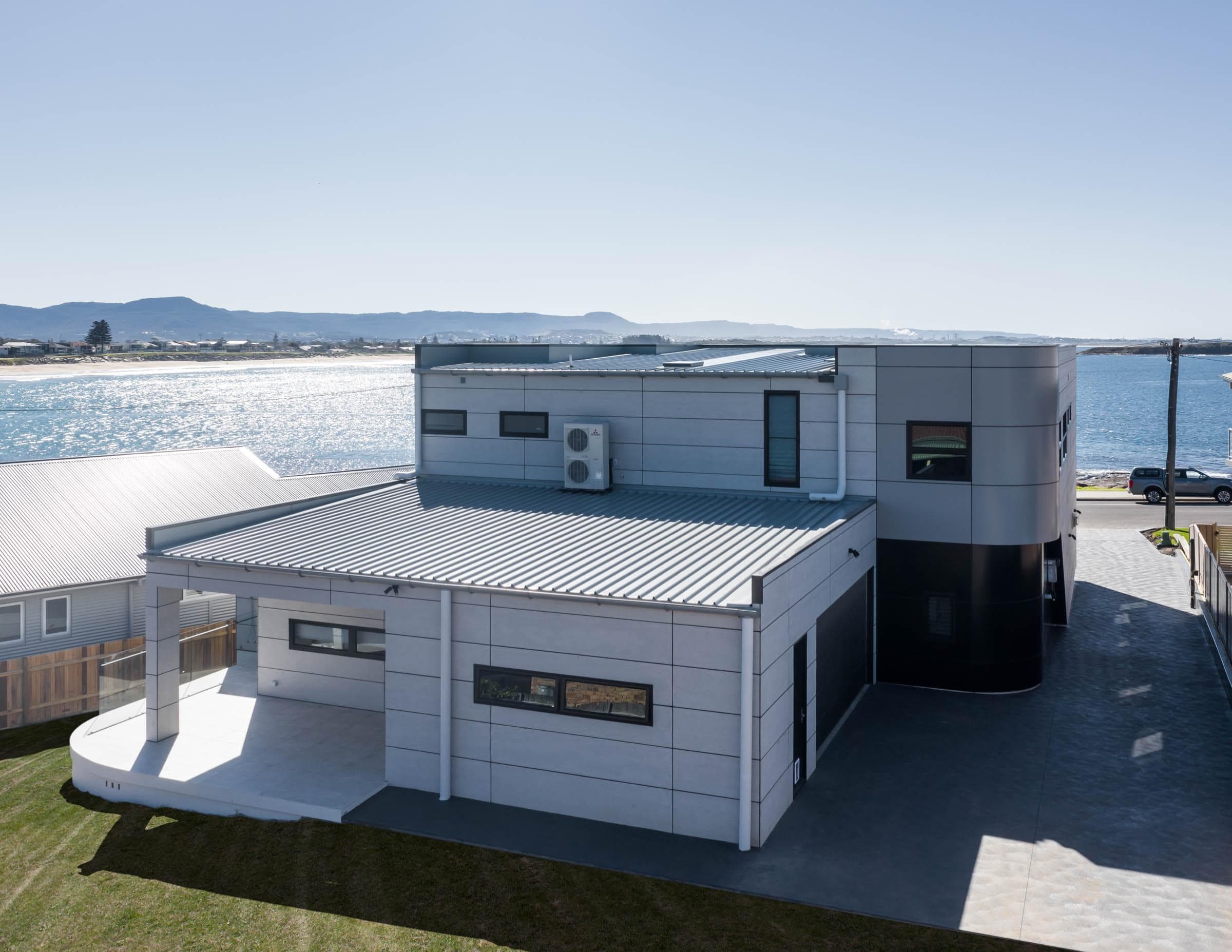 Rear façade of The Icon featuring curved ALPOLIC™/fr Monotone Slate panels along coastal edge