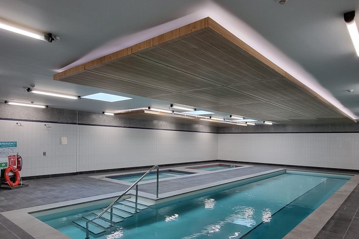 Bespoke wood grain metal ceiling with slotted perforations by durlum in the pool/hydrotherapy area at the Newcastle Knights Centre of Excellence